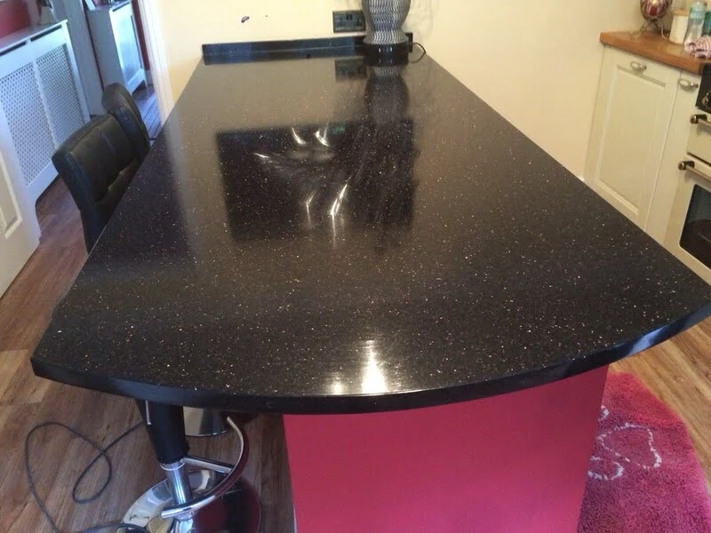 Plan de travail de cuisine en granit Galaxy Noir poli avec base noire profonde et mouches dorées métalliques—granit noir classique avec or pour cuisines modernes.